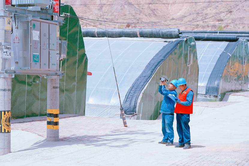 国网兰州供电公司忠和供电所员工在兰州市安宁区九合镇5G智慧农业产业园巡视检查35千伏九合变112俞家湾线兰沟大棚配变台区。史双绚摄